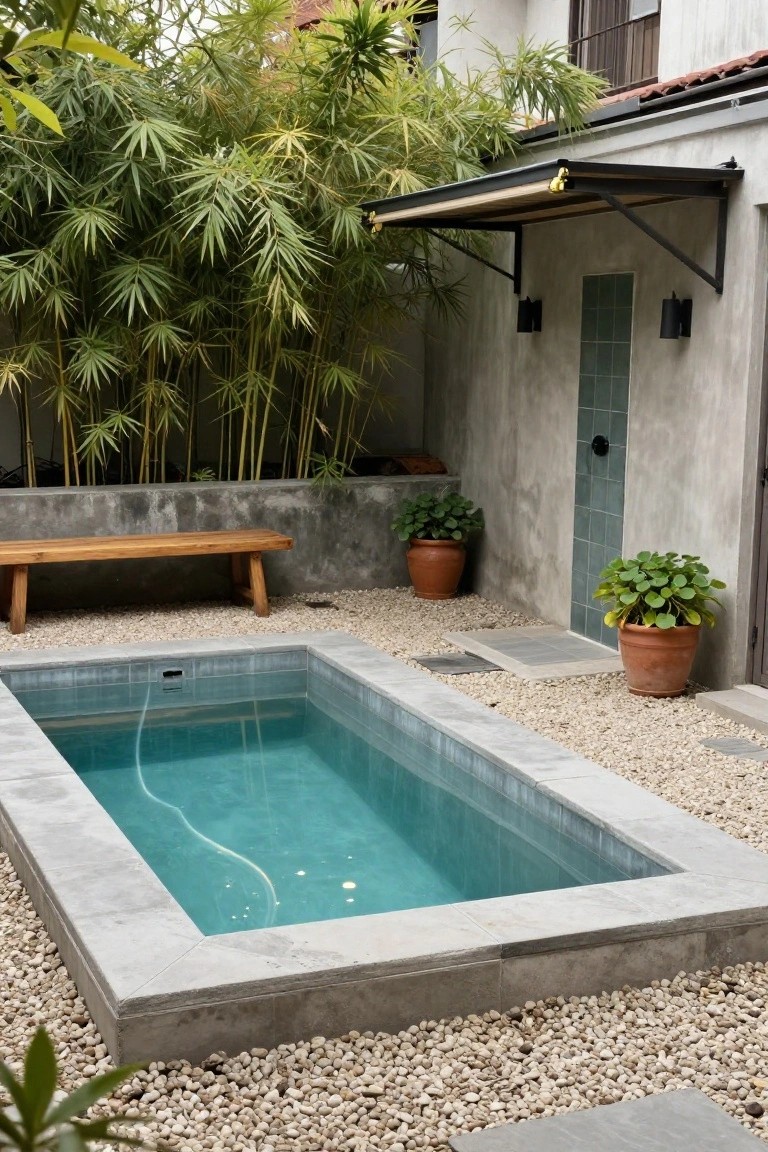 20 Compact Stock Tank Pool Ideas Perfect For Small Spaces Small rectangular turquoise pool with concrete edges set into a gravel courtyard surrounded by bamboo plants, potted greenery, a wooden bench, and textured walls with an awning.