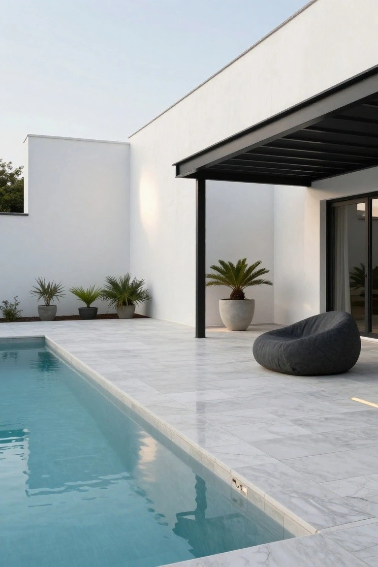 23 Luxurious Backyard Pool Oasis Ideas Worth Saving White modern house with black steel pergola beside a rectangular pool edged in white marble tiles, gray bean bag chair on the terrace, and potted palms nearby.