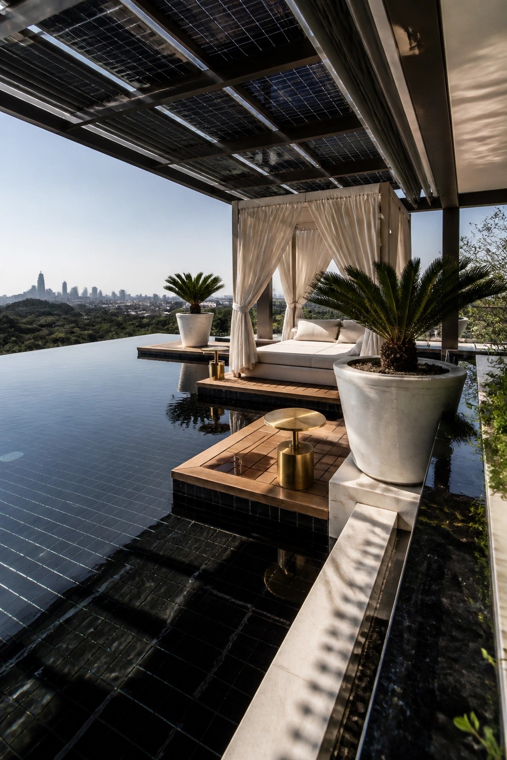 A modern poolside lounge with a white curtained canopy on a wooden deck next to a dark-tiled infinity pool.