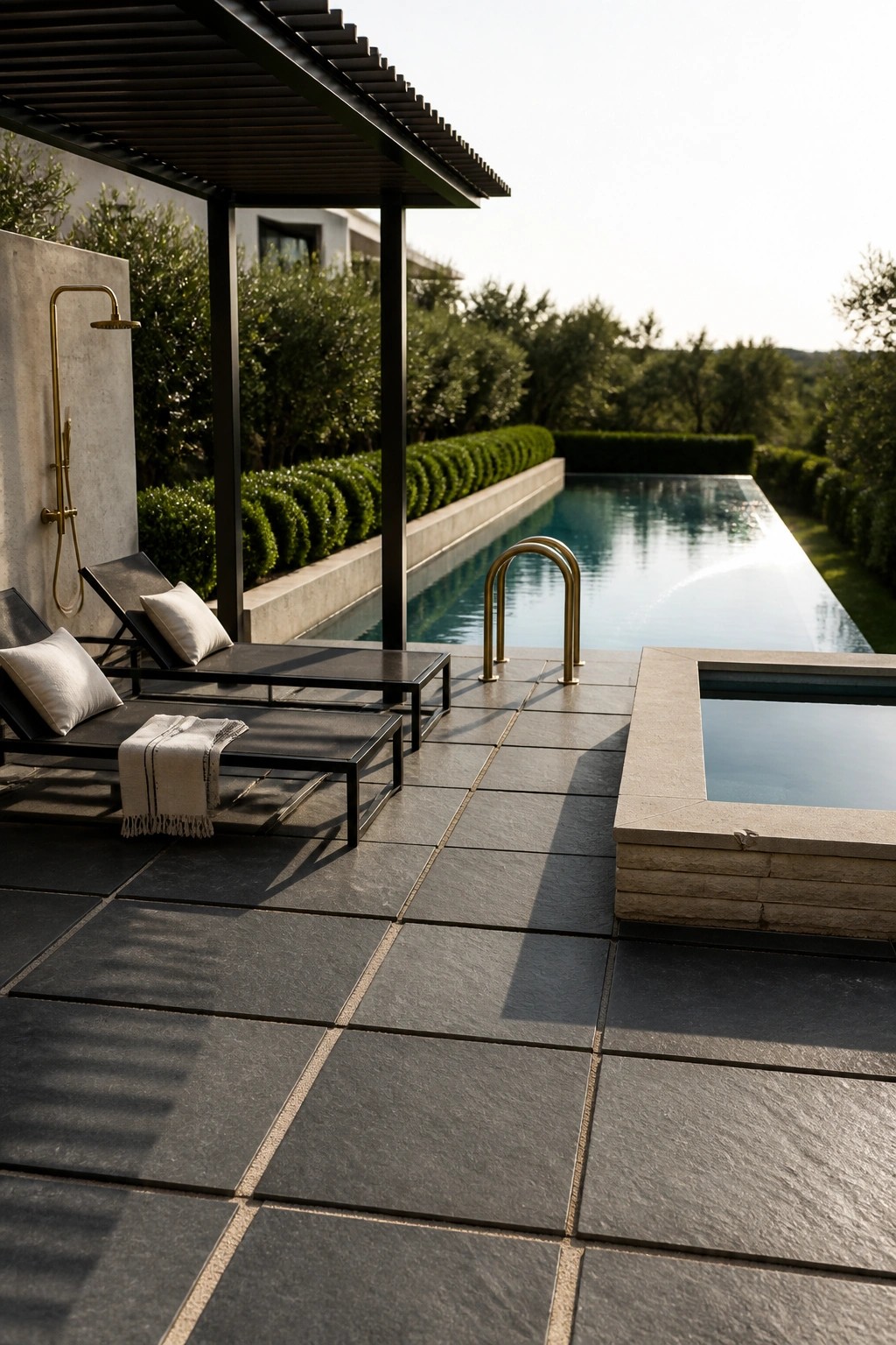 18 Natural Stone Pool Patio Ideas That Blend Beautifully Into Landscaping Modern luxury patio with infinity pool, black loungers, brass shower, and stone hot tub.