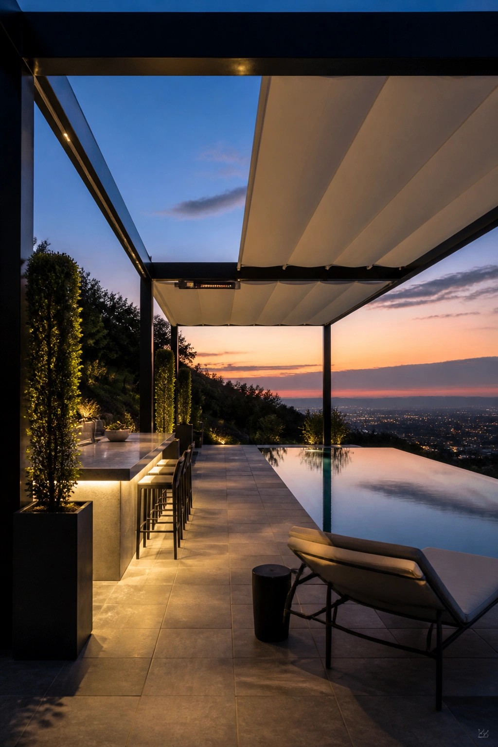 Modern patio with infinity pool, bar stools, and lounge chair at sunset