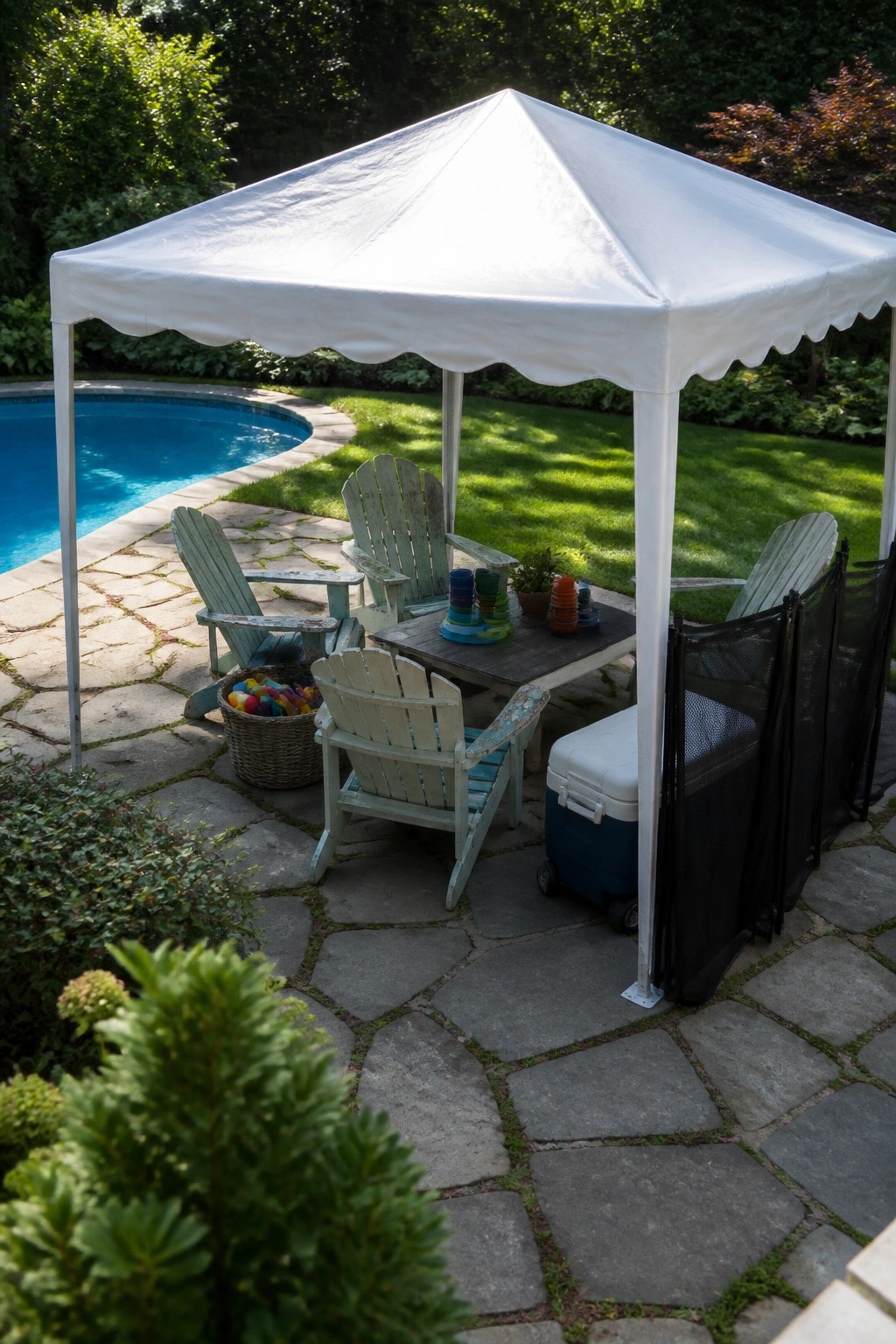 19 Versatile Temporary Pool Shade Ideas for Seasonal Pool Setups A white pop-up canopy tent covers a stone patio with several Adirondack chairs, a table, and a cooler beside a swimming pool.