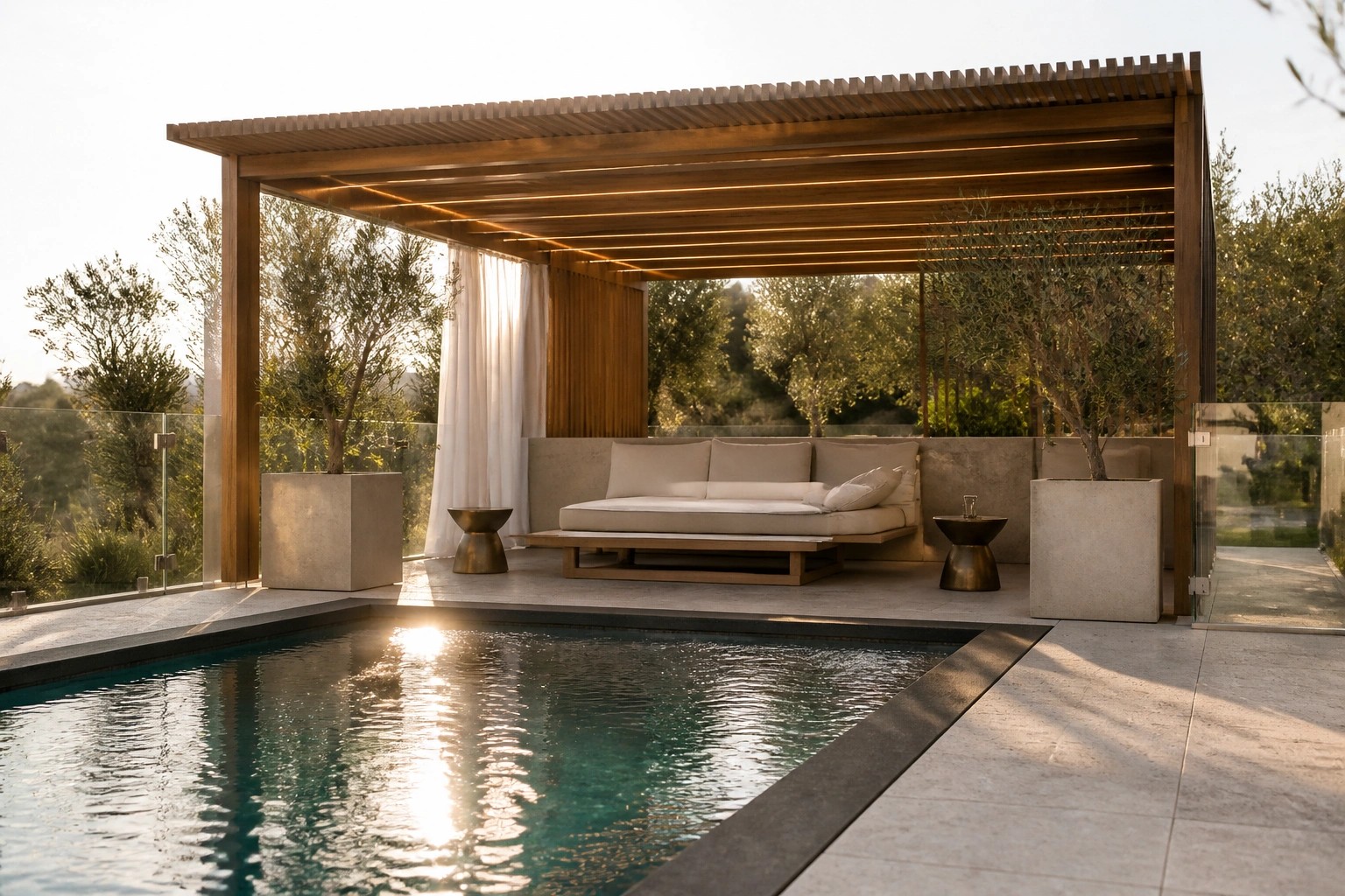 21 Luxurious Pergola Over Pool Ideas for Elevated Poolside Living A wooden pergola with a slatted roof shelters a long cushioned bench beside a rectangular pool, flanked by potted olive trees and white curtains.