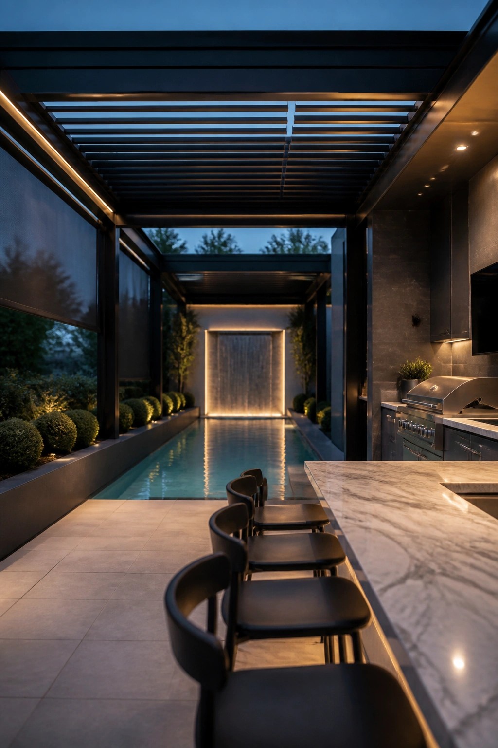 An outdoor pool area covered by a dark slatted pergola, with a marble countertop, black bar stools, and built-in grill along one side.