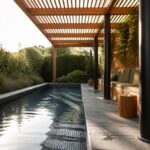A long narrow pool runs alongside a wooden pergola with slatted roof, black support posts, and built-in green cushioned seating next to a vertical garden wall.