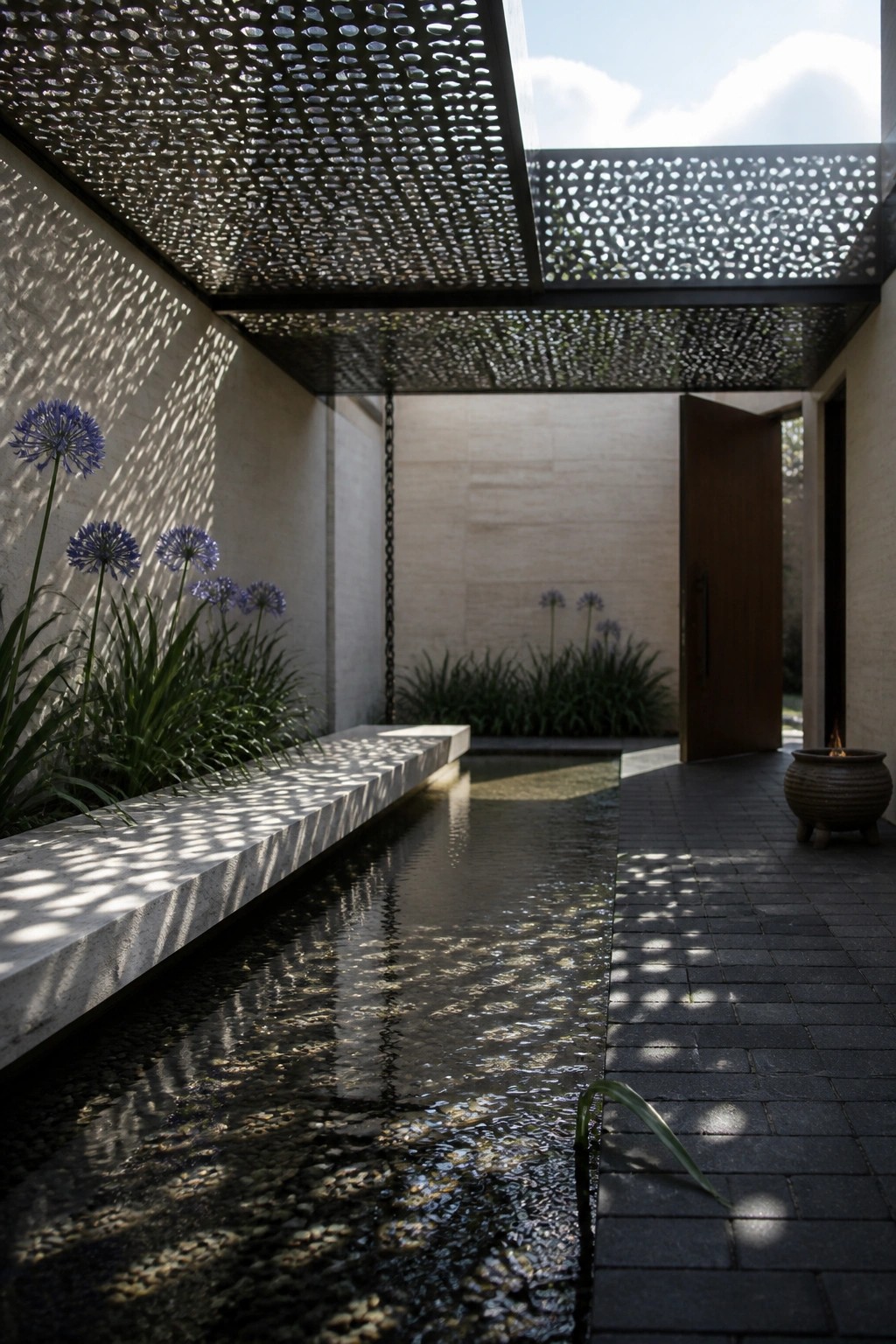 22 Contemporary Pool Shade Ideas in Minimalist Outdoor Settings A minimalist outdoor courtyard with a long water channel, stone bench, blue flowers along one wall, and a large perforated metal screen overhead casting dappled shadows on a paved walkway.
