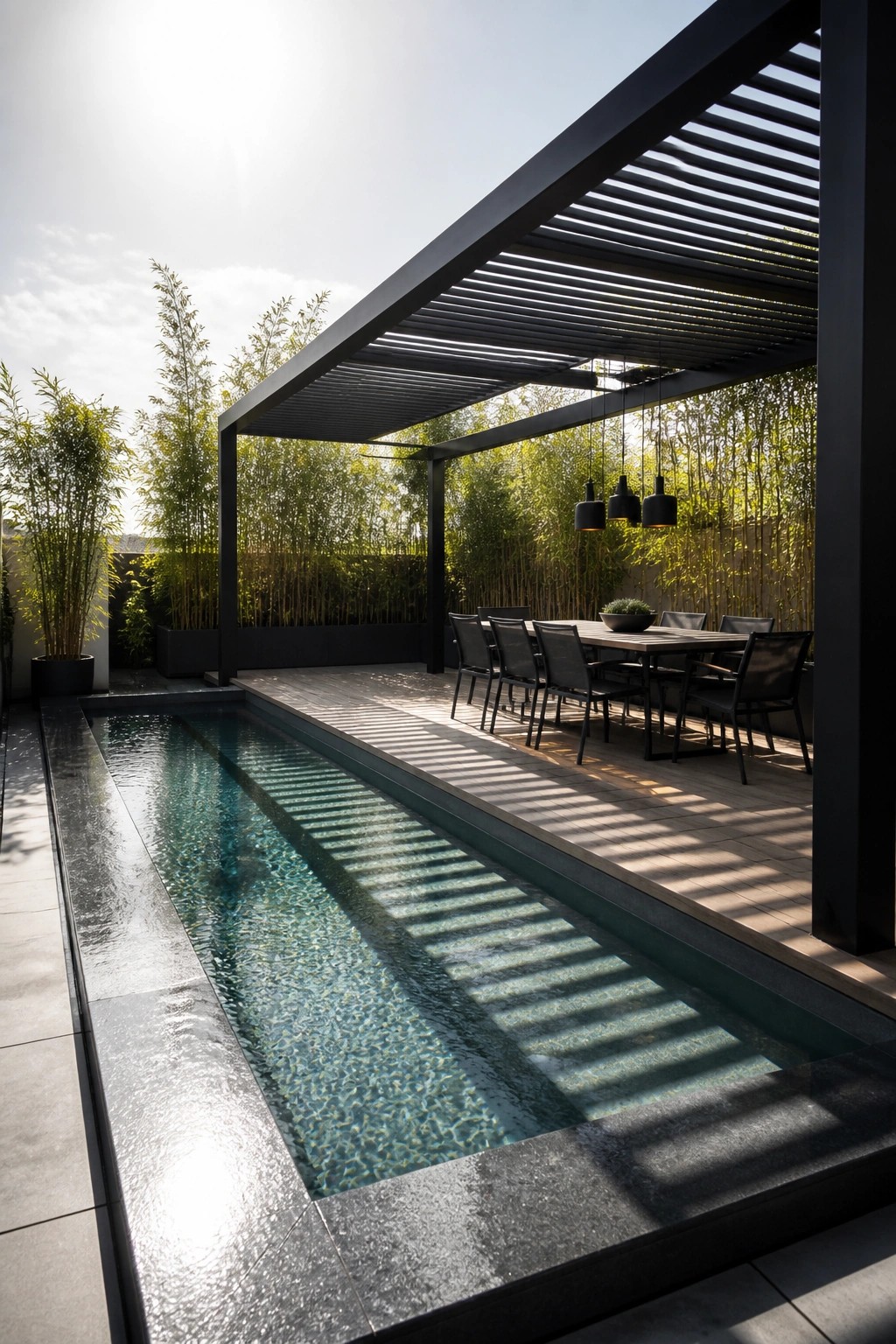 24 Inspiring Permanent Pool Shade Ideas Built for Long-Term Sun Protection Modern patio with long pool, black dining set, and pendant lights under slatted pergola