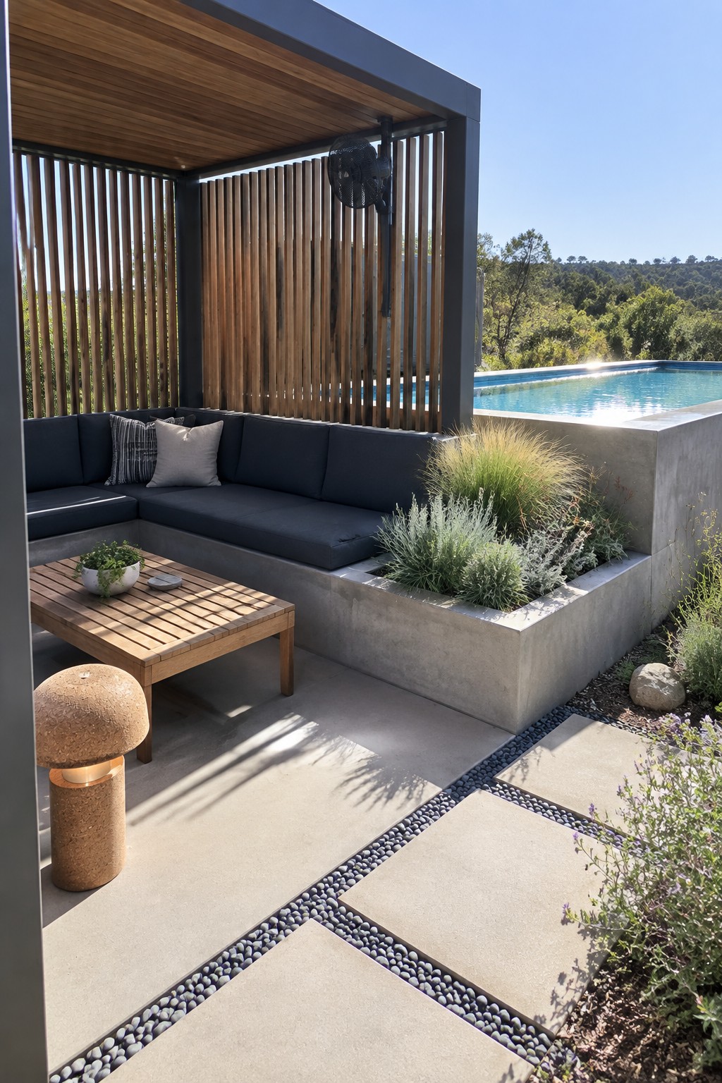 14 Functional Above Ground Pool Cabana Ideas for Shaded Lounging An outdoor cabana with dark sectional seating, a wooden coffee table, integrated concrete planters with grasses, and a swimming pool visible to the right.