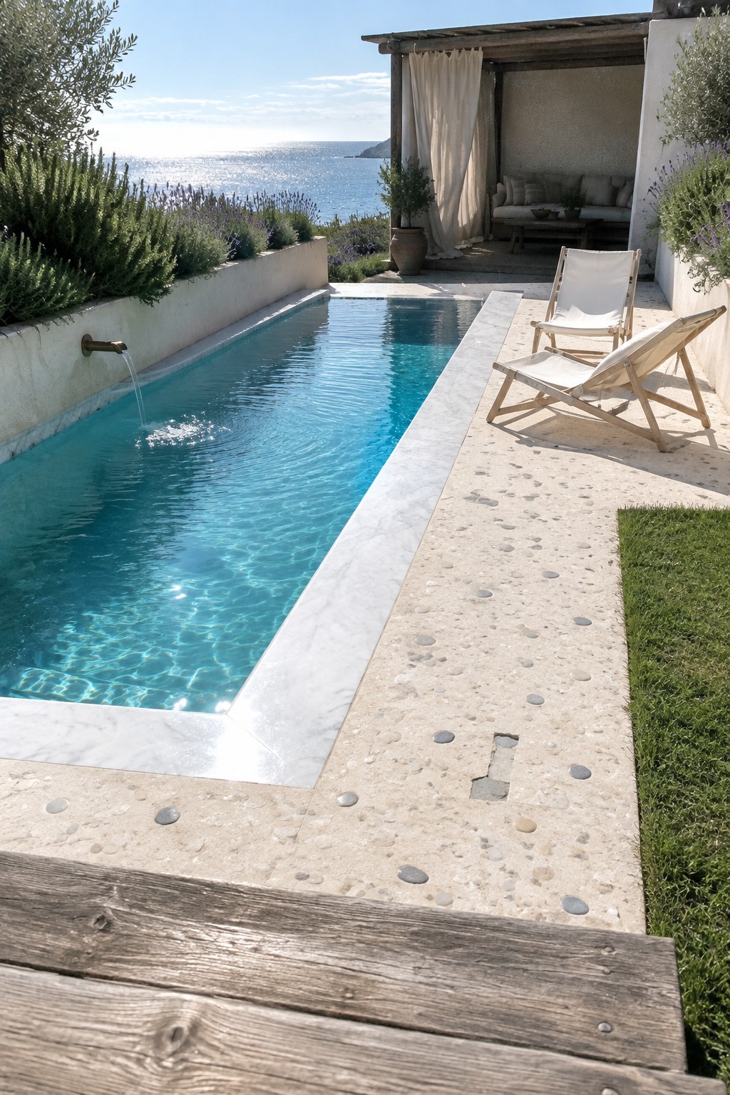 18 Distinctive Infinity Pool Edge Details Featuring Refined Coping Designs Turquoise pool with lounge chairs on pebble-stone patio overlooking the sea