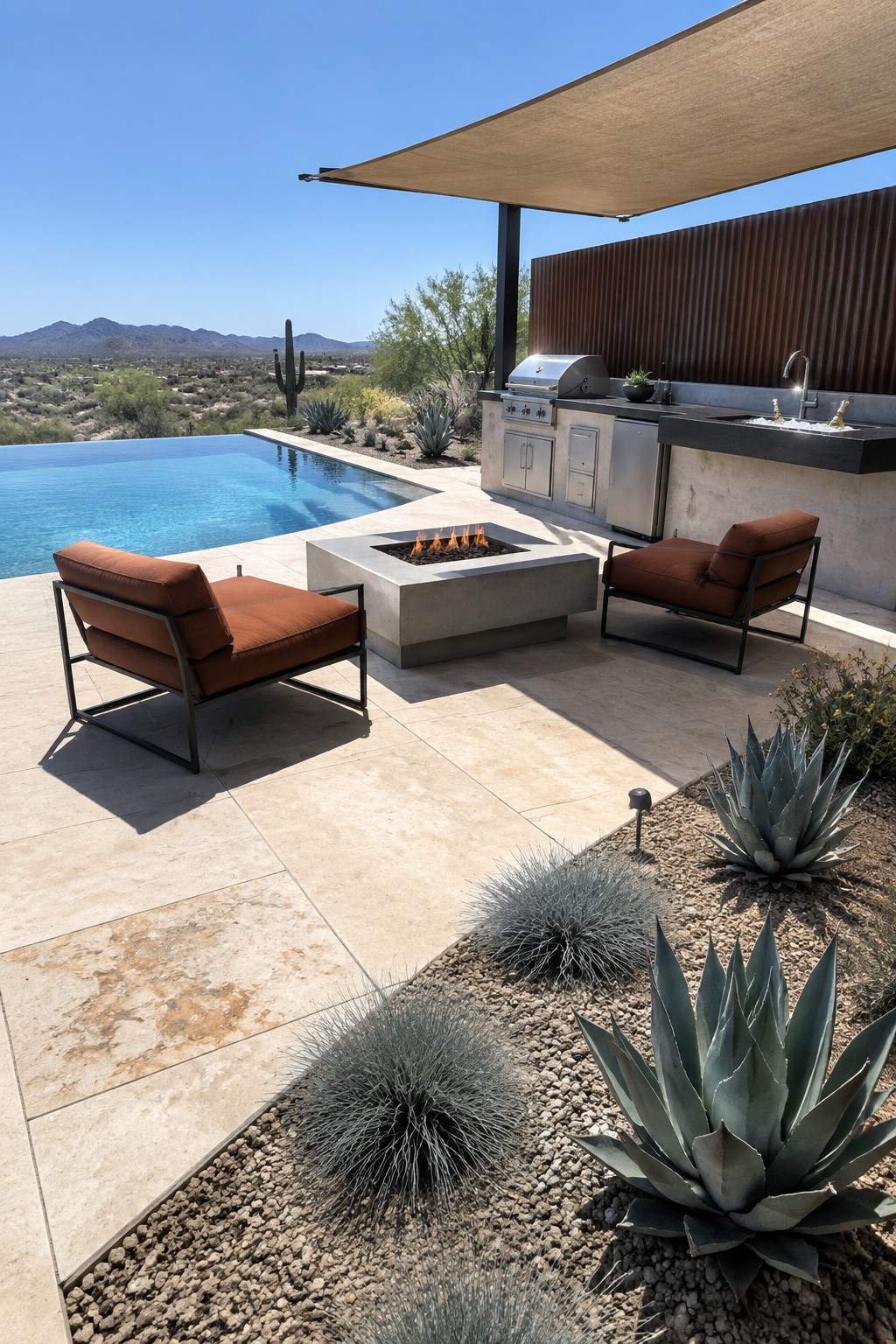 18 Stunning Backyard Infinity Pool Ideas With Modern Outdoor Layouts Modern desert backyard showing an infinity pool, square concrete fire pit with flames, two rust-colored lounge chairs, outdoor kitchen under a shade sail, and desert plants in gravel.