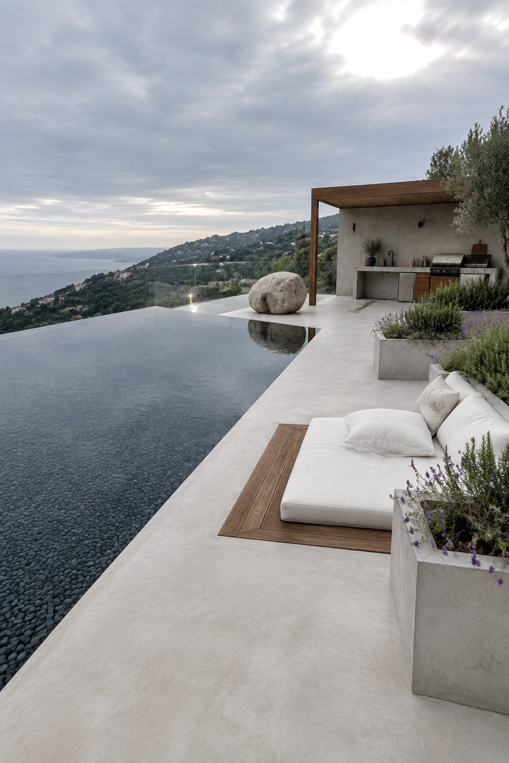 Infinity pool terrace with white lounge seating, outdoor kitchen, and scenic sea view